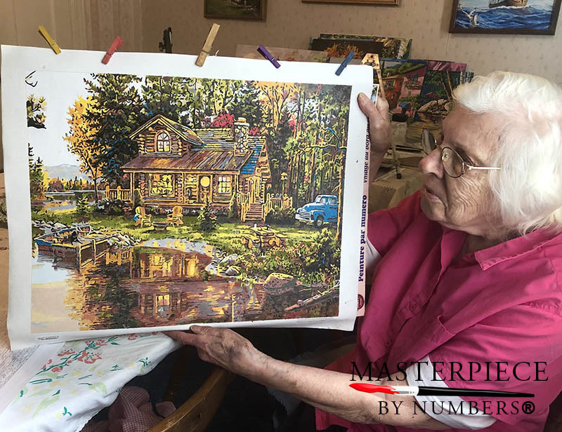 Roxy Ross, 96, with her finished Peace River Cabin paint by numbers painting