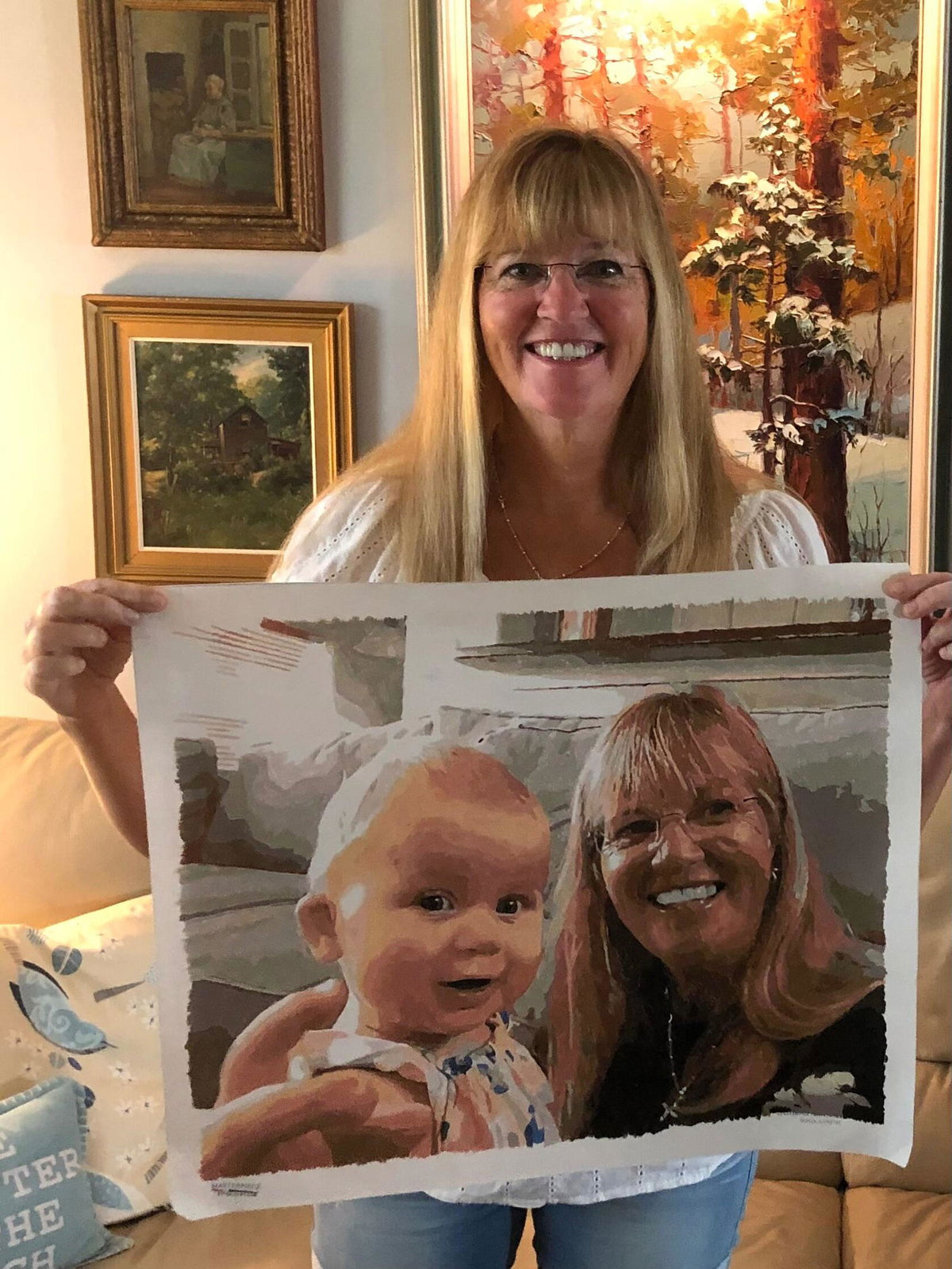 Sonja holding her custom paint by numbers portrait of herself and granddaughter Lucy
